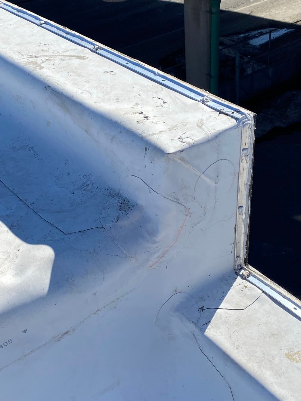 Close-up of a weathered roof seam showing wear and tear on a flat surface.