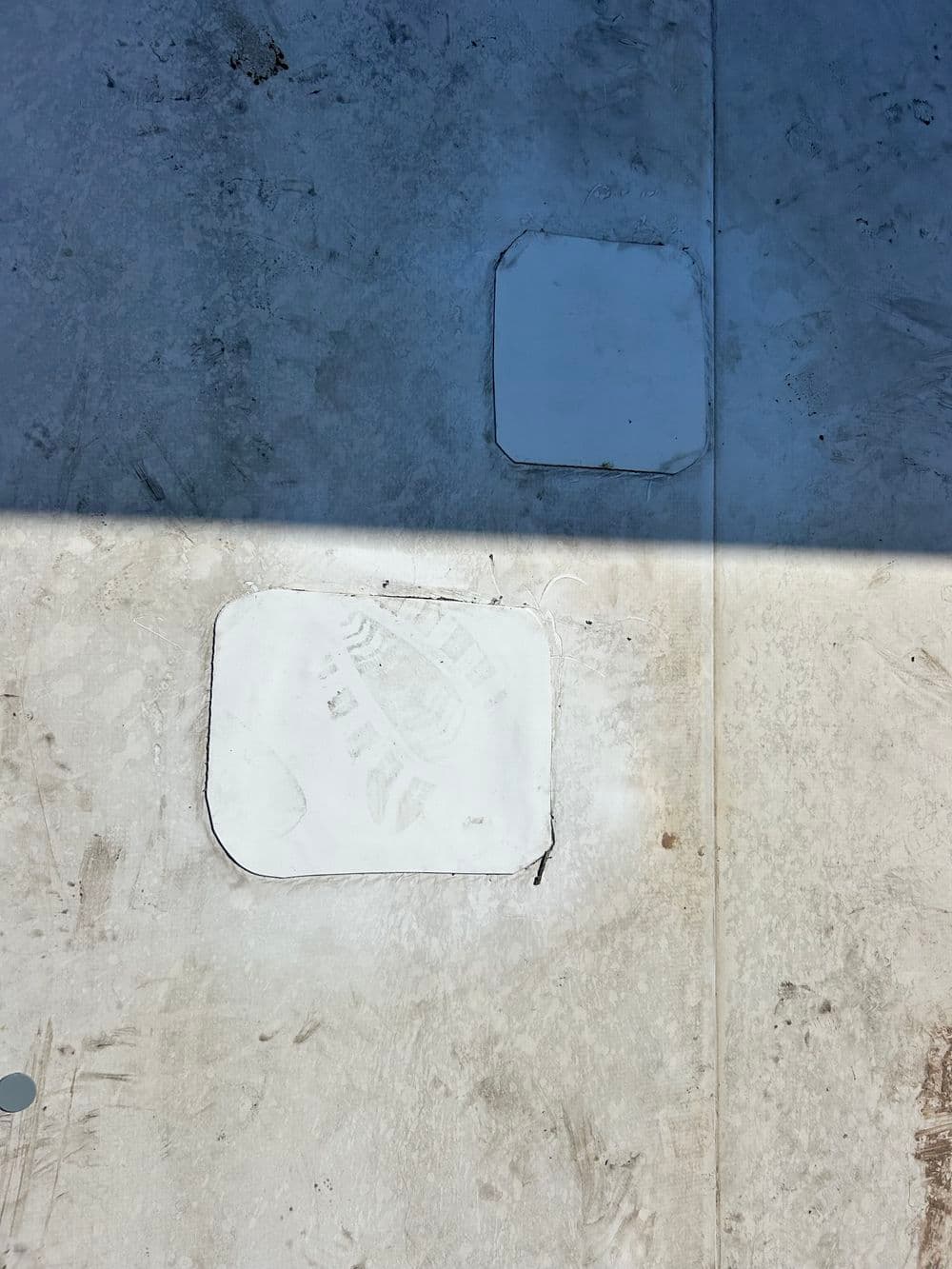 Cleared section of concrete floor with outlined cutouts for future installations.